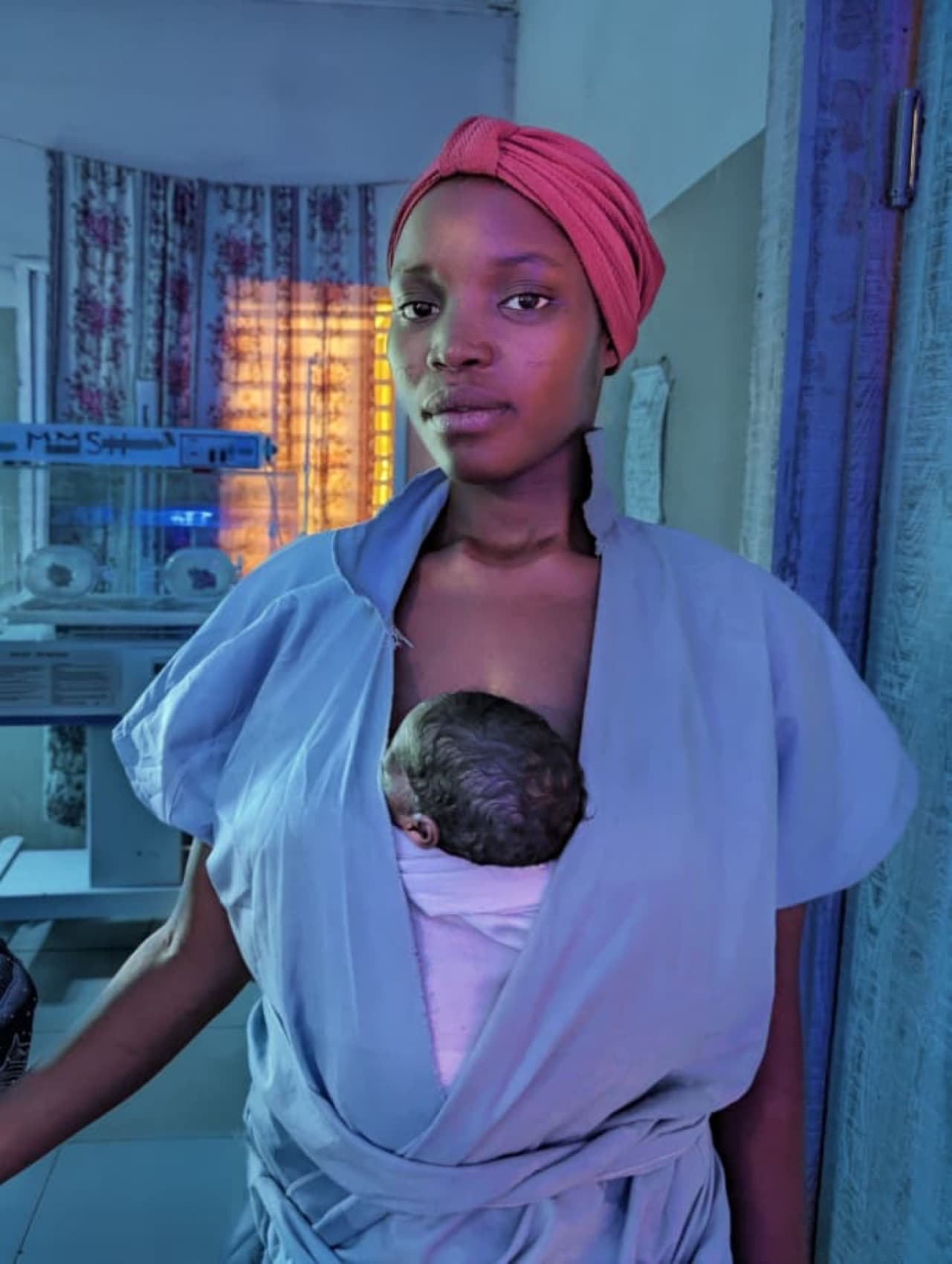 A mother carrying her newborn skin-to-skin in a Kangaroo Care wrap
